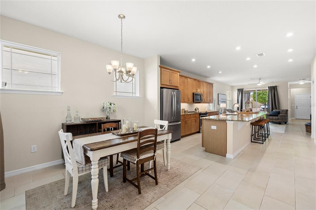 16716 Wingspread Loop Winter Garden, FL 34787 - Photo 12 of 56 a room with stainless steel appliances kitchen island granite countertop furniture and a dining table