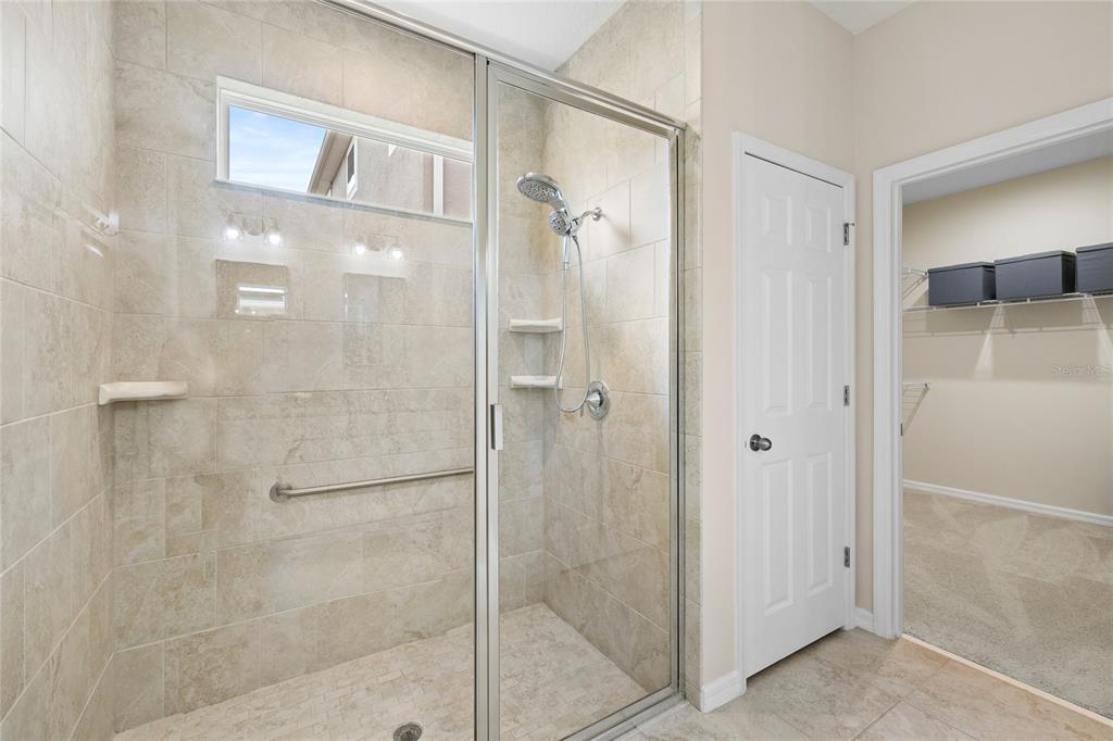 16716 Wingspread Loop Winter Garden, FL 34787 - Photo 21 of 56 a bathroom with a glass shower door