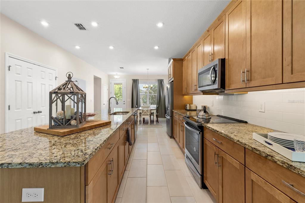 16716 Wingspread Loop Winter Garden, FL 34787 - Photo 4 of 56 a kitchen with stainless steel appliances granite countertop a sink stove and cabinets