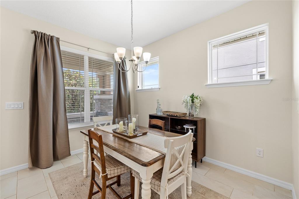 16716 Wingspread Loop Winter Garden, FL 34787 - Photo 10 of 56 a dining room with furniture a chandelier and wooden floor