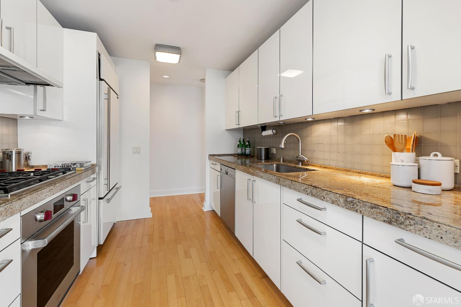 188 Minna, Unit 24A San Francisco, CA 94105 - Photo 14 of 43 a kitchen with granite countertop a sink a stove and cabinets