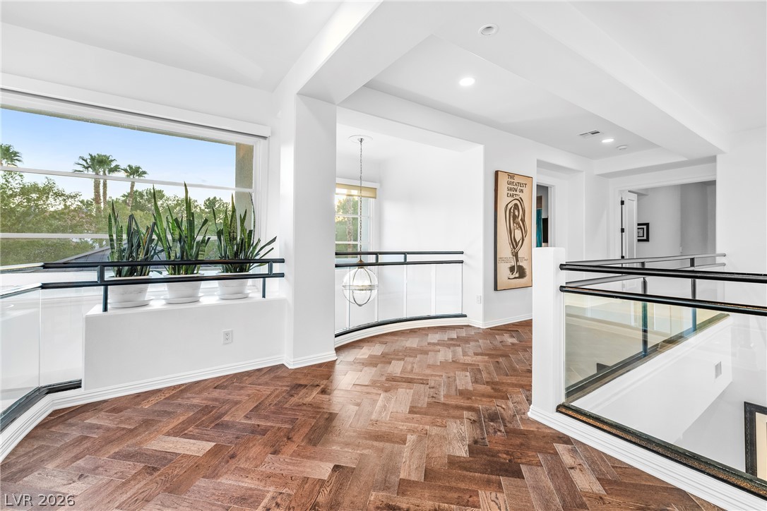2000 Grouse Street Las Vegas, NV 89134 - Photo 32 of 89 Herringbone hardwood floors extend through this naturally illuminated hallway with modern glass railings.