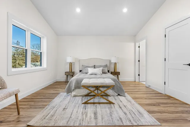 a bedroom with a bed and wooden floor