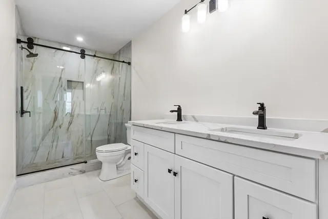 a bathroom with a sink a toilet and shower