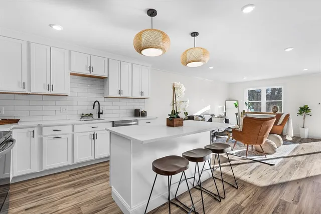 a kitchen with stainless steel appliances granite countertop a table and chairs in it