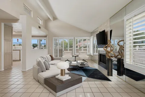 a living room with furniture a flat screen tv and a large window