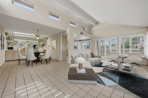 a view of a dining room with furniture and a chandelier fan