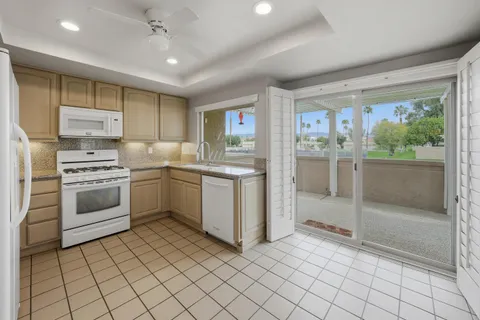 a kitchen with cabinets stainless steel appliances and a window