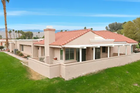 a view of a house with a garden and deck