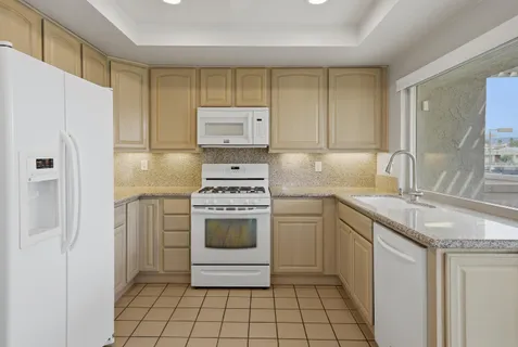 a kitchen with granite countertop a sink and a refrigerator