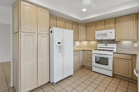 a view of a livingroom with furniture flat screen tv and floor to ceiling window