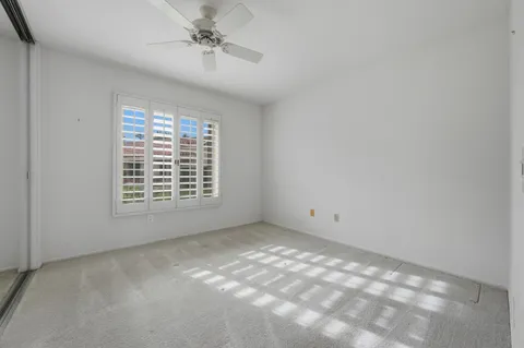 a bathroom with a granite countertop sink a toilet and a mirror