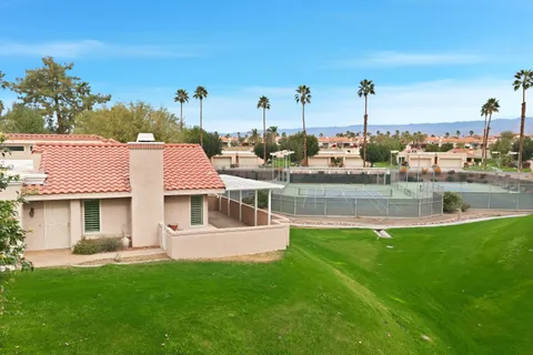 a view of a house with a backyard and a tree