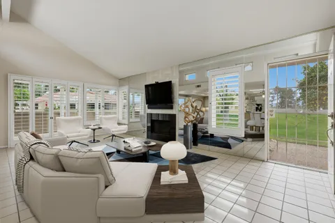 a living room with furniture a fireplace and a floor to ceiling window