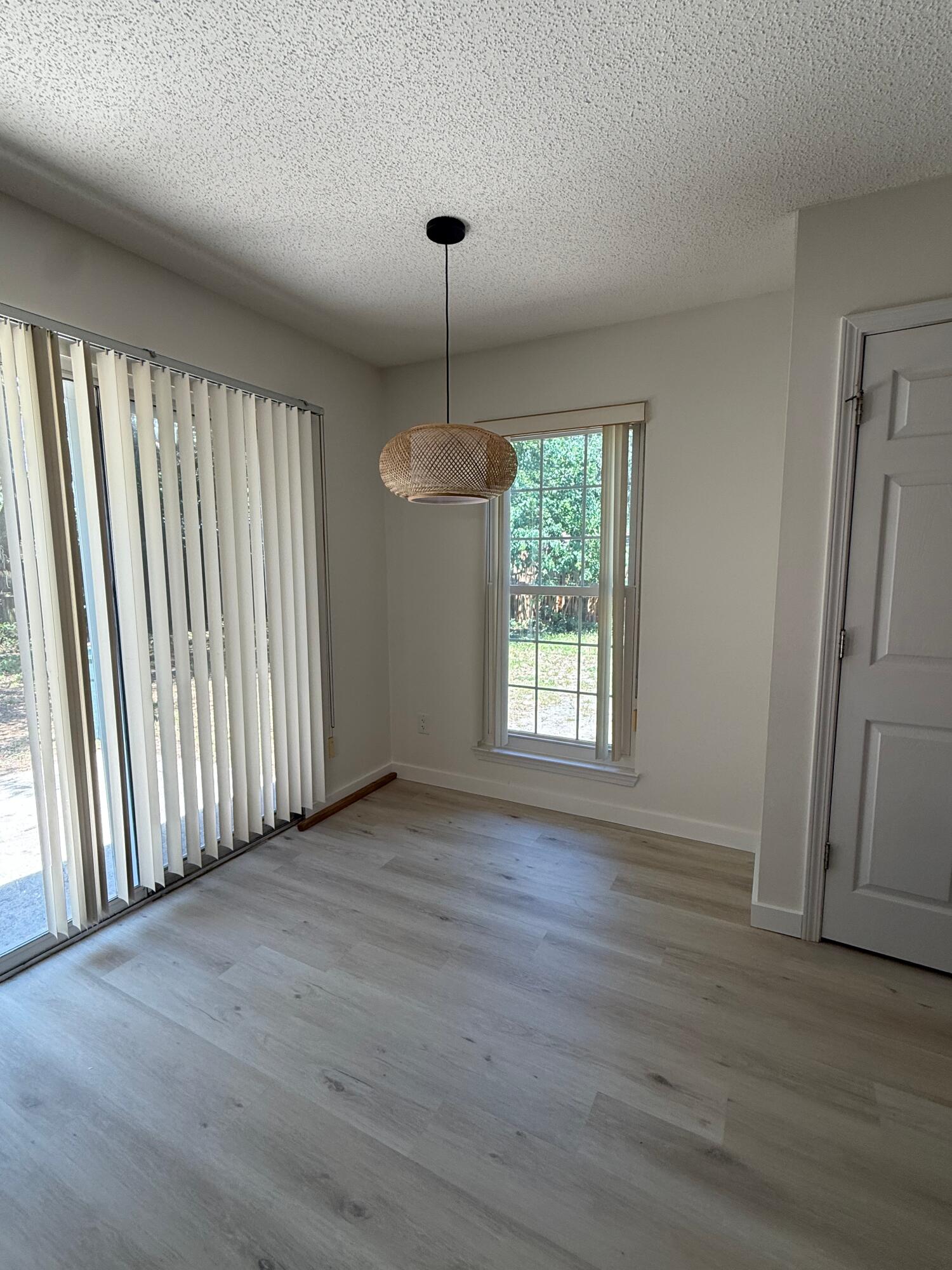 910 Elizabeth Lane Shalimar, FL 32579 - Photo 11 of 16 an empty room with wooden floor and windows