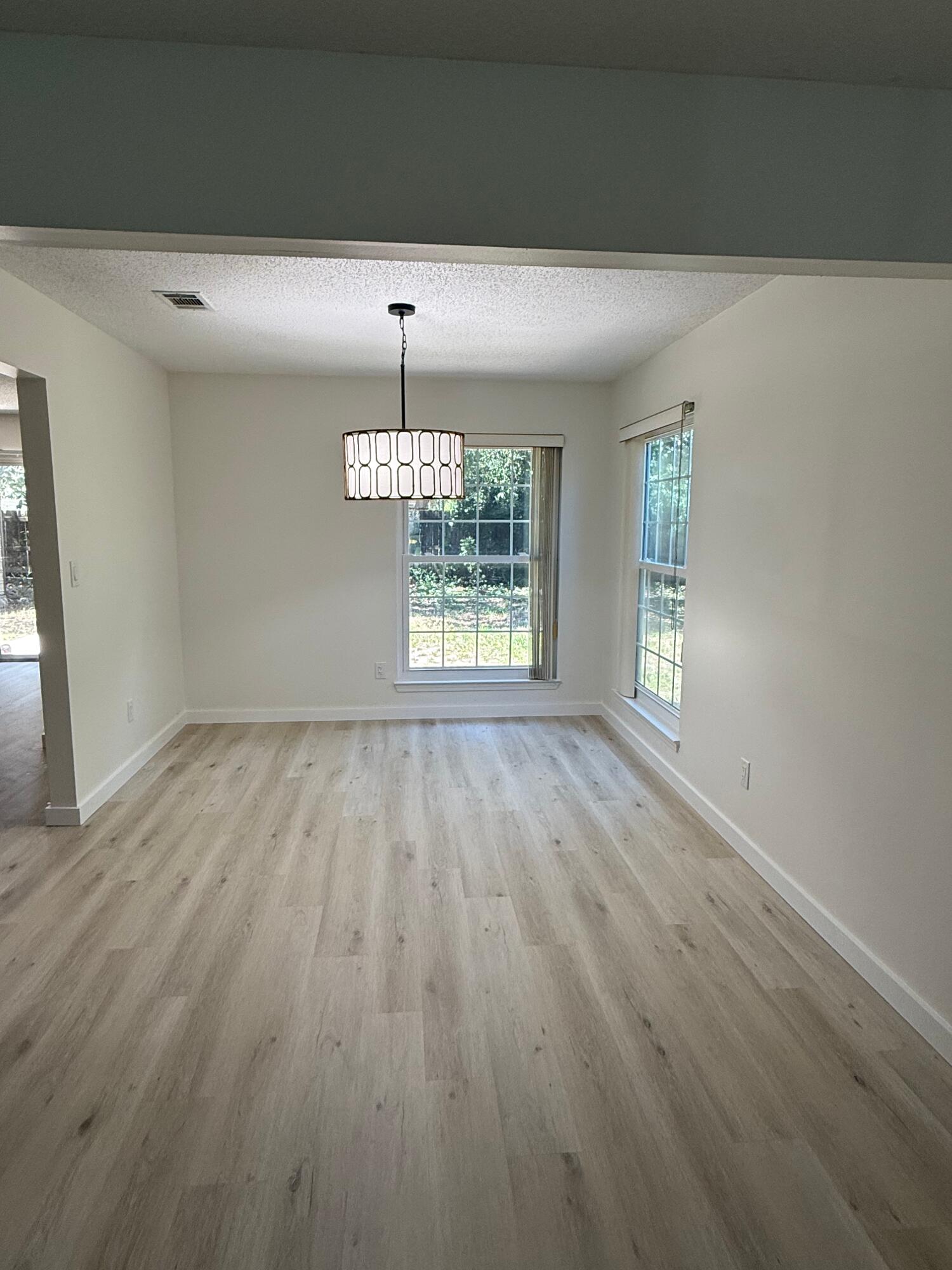 910 Elizabeth Lane Shalimar, FL 32579 - Photo 2 of 16 wooden floor in an empty room with a window