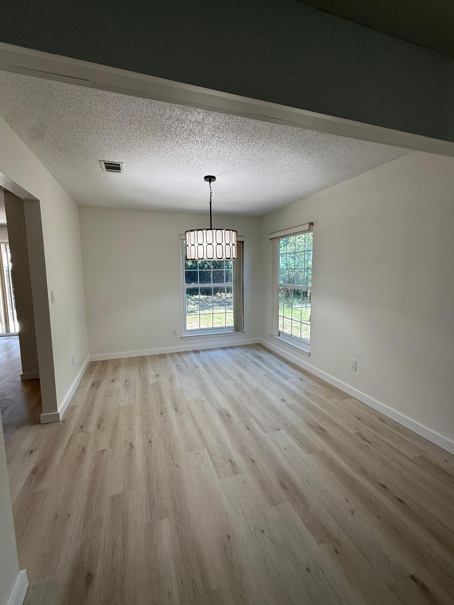 910 Elizabeth Lane Shalimar, FL 32579 - Photo 6 of 16 wooden floor in an empty room with a window