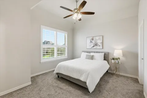 a bedroom with a bed and a large window