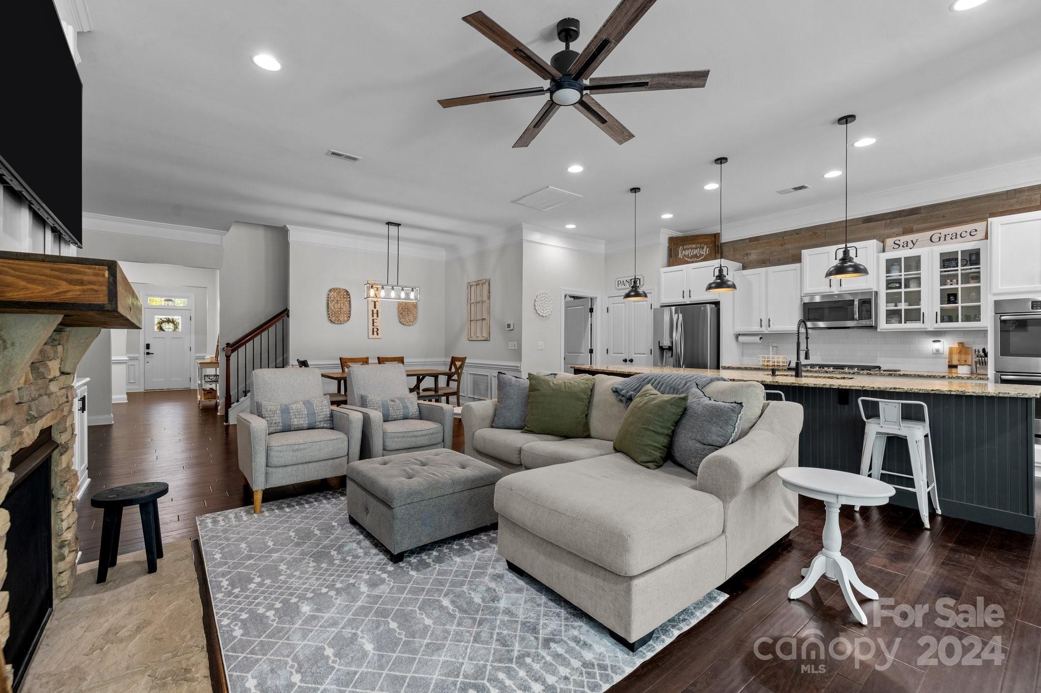 1846 Larkspur Way Tega Cay, SC 29708 - Photo 26 of 46 a living room with furniture and a flat screen tv with kitchen view
