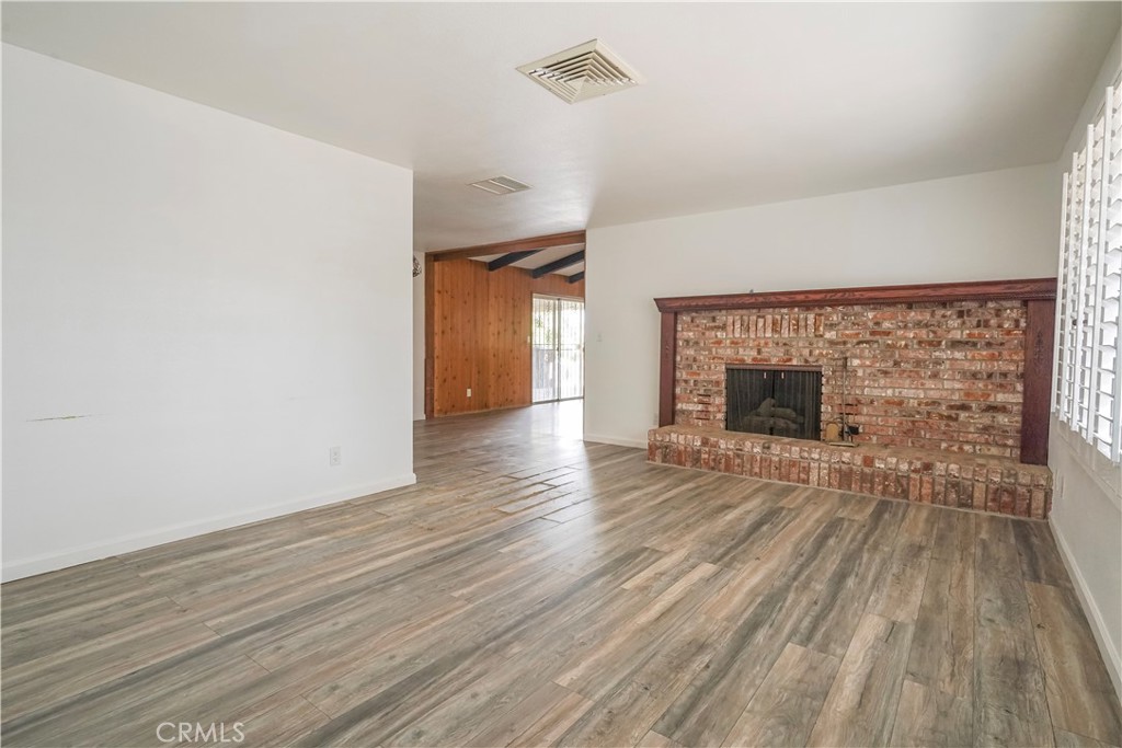 56320 Tamarisk Court Yucca Valley, CA 92284 - Photo 13 of 46 a view of empty room with wooden floor and fireplace