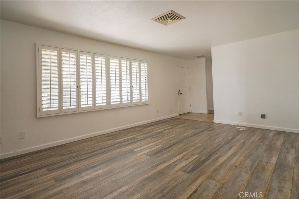 56320 Tamarisk Court Yucca Valley, CA 92284 - Photo 14 of 46 a view of an empty room with wooden floor and a window