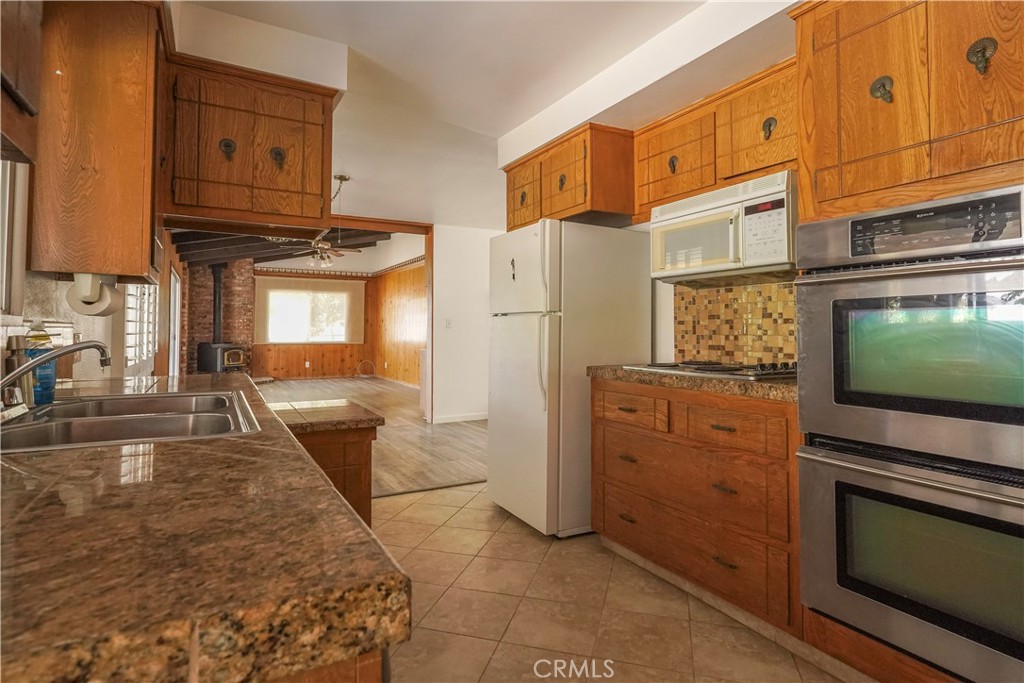56320 Tamarisk Court Yucca Valley, CA 92284 - Photo 17 of 46 a kitchen view with granite countertop a stove and a microwave