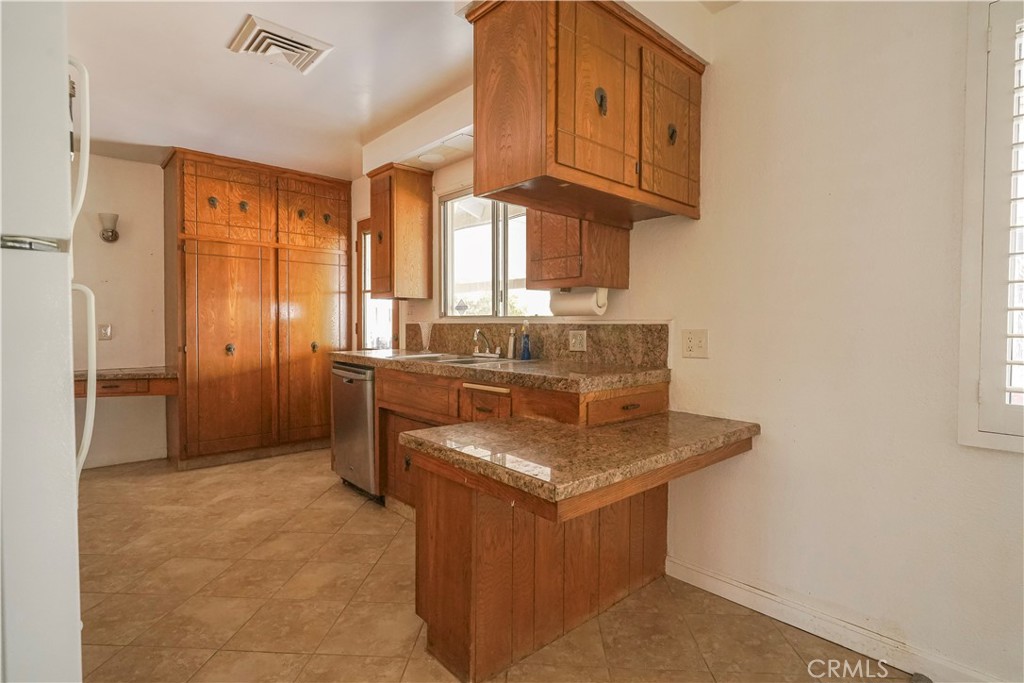 56320 Tamarisk Court Yucca Valley, CA 92284 - Photo 18 of 46 a kitchen with stainless steel appliances granite countertop a sink stove and cabinets