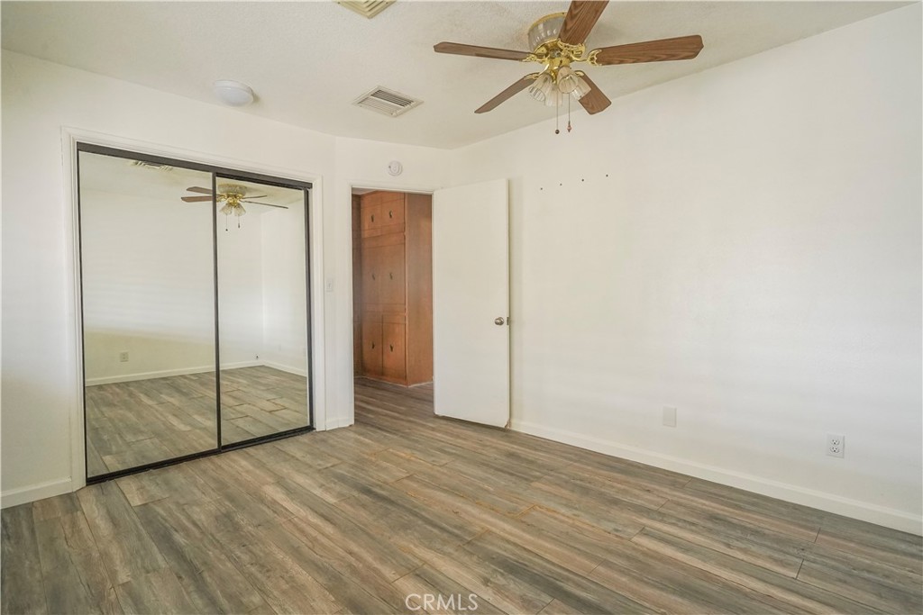 56320 Tamarisk Court Yucca Valley, CA 92284 - Photo 28 of 46 an empty room with wooden floor closet and fan