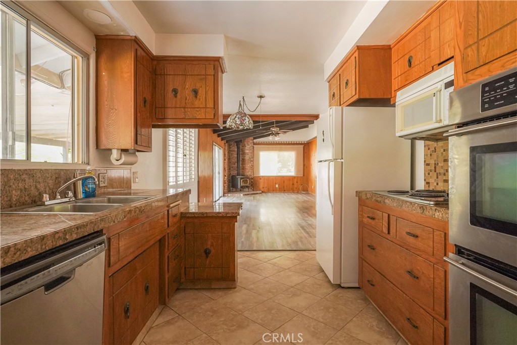 56320 Tamarisk Court Yucca Valley, CA 92284 - Photo 3 of 46 a kitchen with stainless steel appliances granite countertop a sink stove and refrigerator