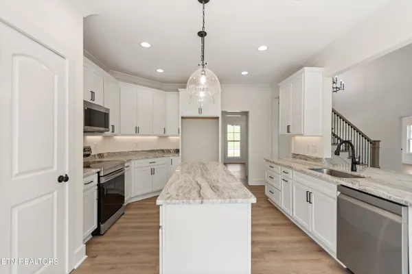 a kitchen with stainless steel appliances granite countertop a sink stove and refrigerator