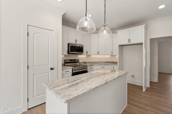 a kitchen with stainless steel appliances granite countertop a sink refrigerator and microwave