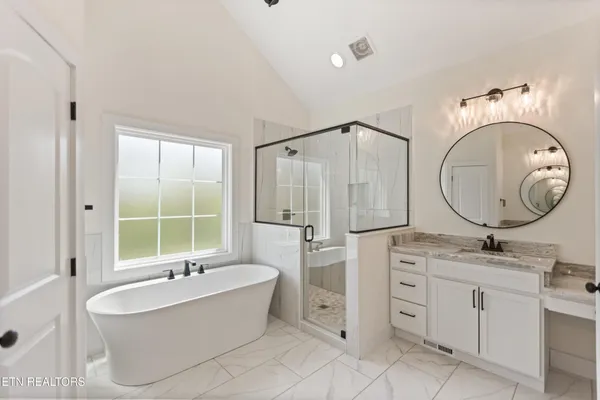 a bathroom with a tub sink and mirror