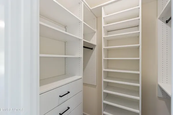 a view of walk in closet with empty racks
