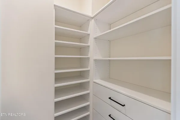 a view of walk in closet with empty racks