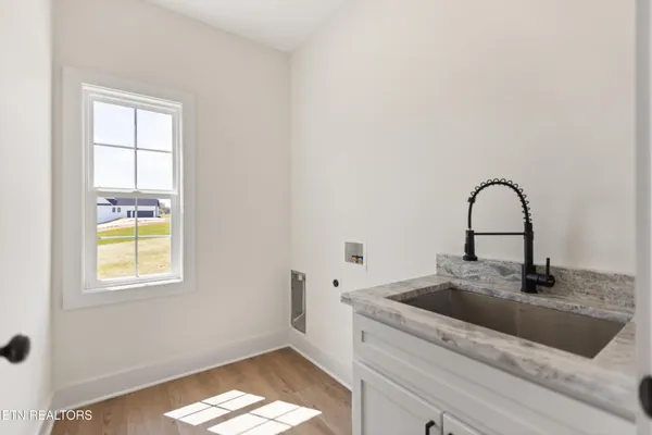 a close view of a sink and dishwasher with wooden floor