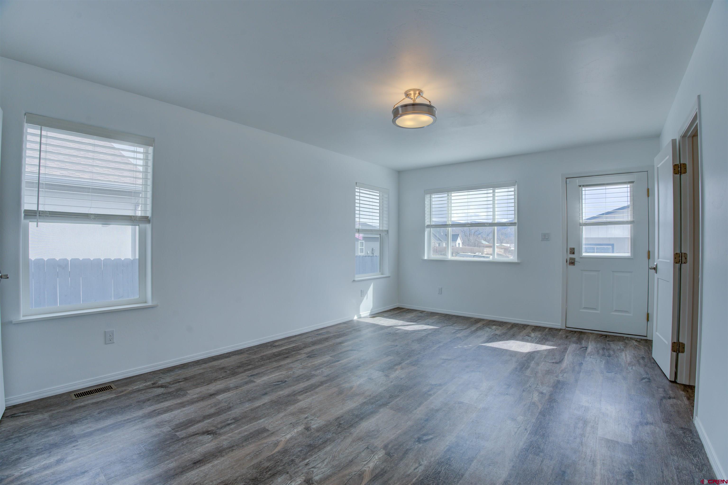 431 Juniper Place Cortez, CO 81321 - Photo 17 of 36 an empty room with wooden floor and windows