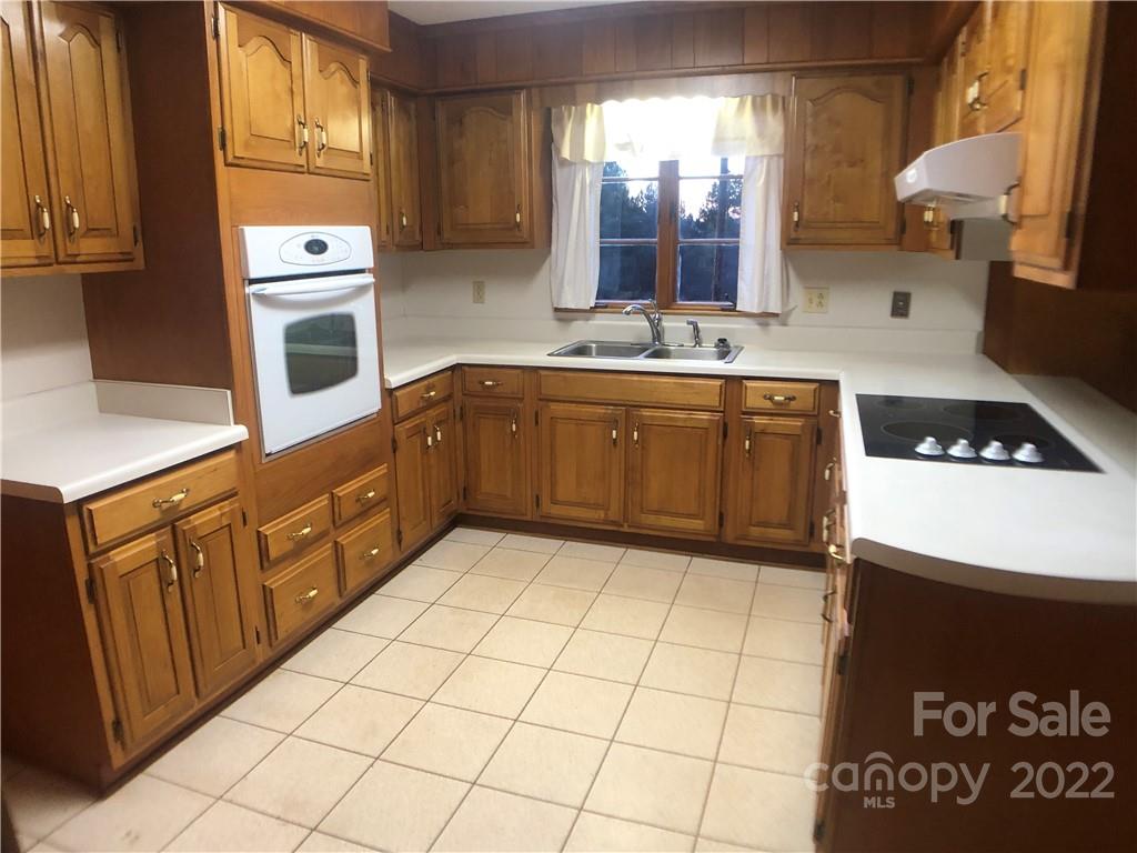 178 Skyview Ridge Rutherfordton, NC 28139 - Photo 24 of 43 a kitchen with stainless steel appliances granite countertop a sink a stove cabinets and wooden floor