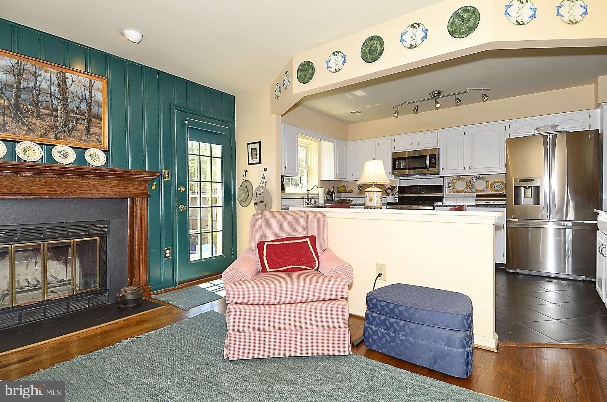 10708 Brewer House Road North Bethesda, MD 20852 - Photo 10 of 26 a living room with furniture and a fireplace with kitchen view