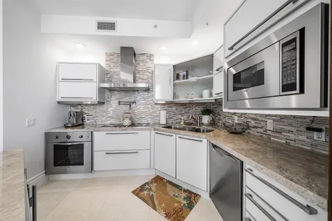 a living room with furniture a chandelier and a large window