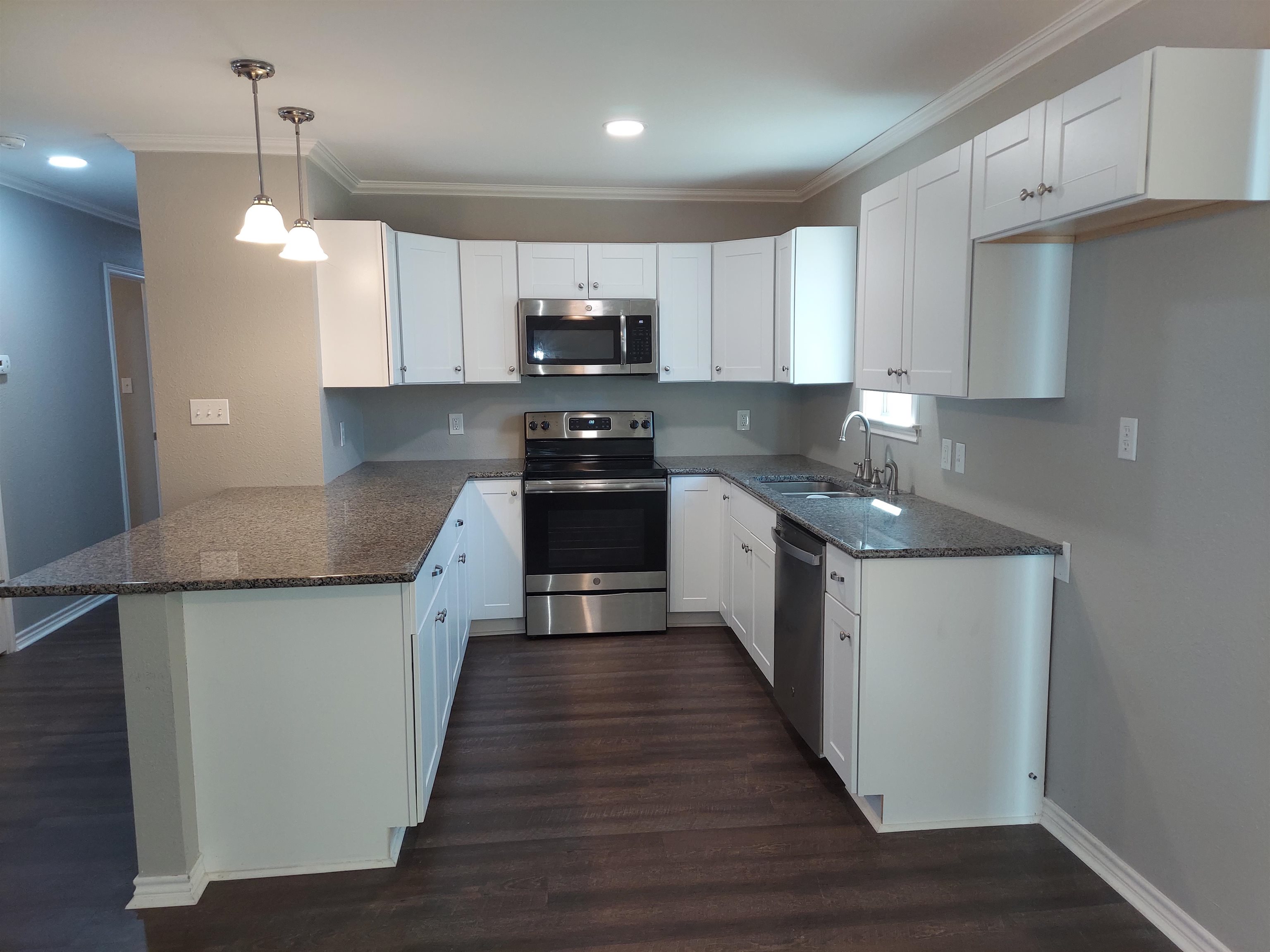 606 South Pierce Street Burnet, TX 78611 - Photo 4 of 9 a kitchen with stainless steel appliances granite countertop a sink a stove and a wooden floors
