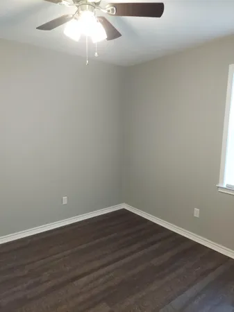 a view of a small space with wooden floor and window