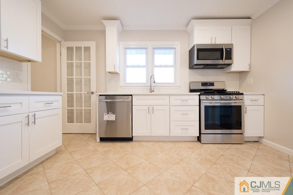 5 High Point Road East Brunswick, NJ 08816 - Photo 8 of 24 a kitchen with cabinets stainless steel appliances and a window