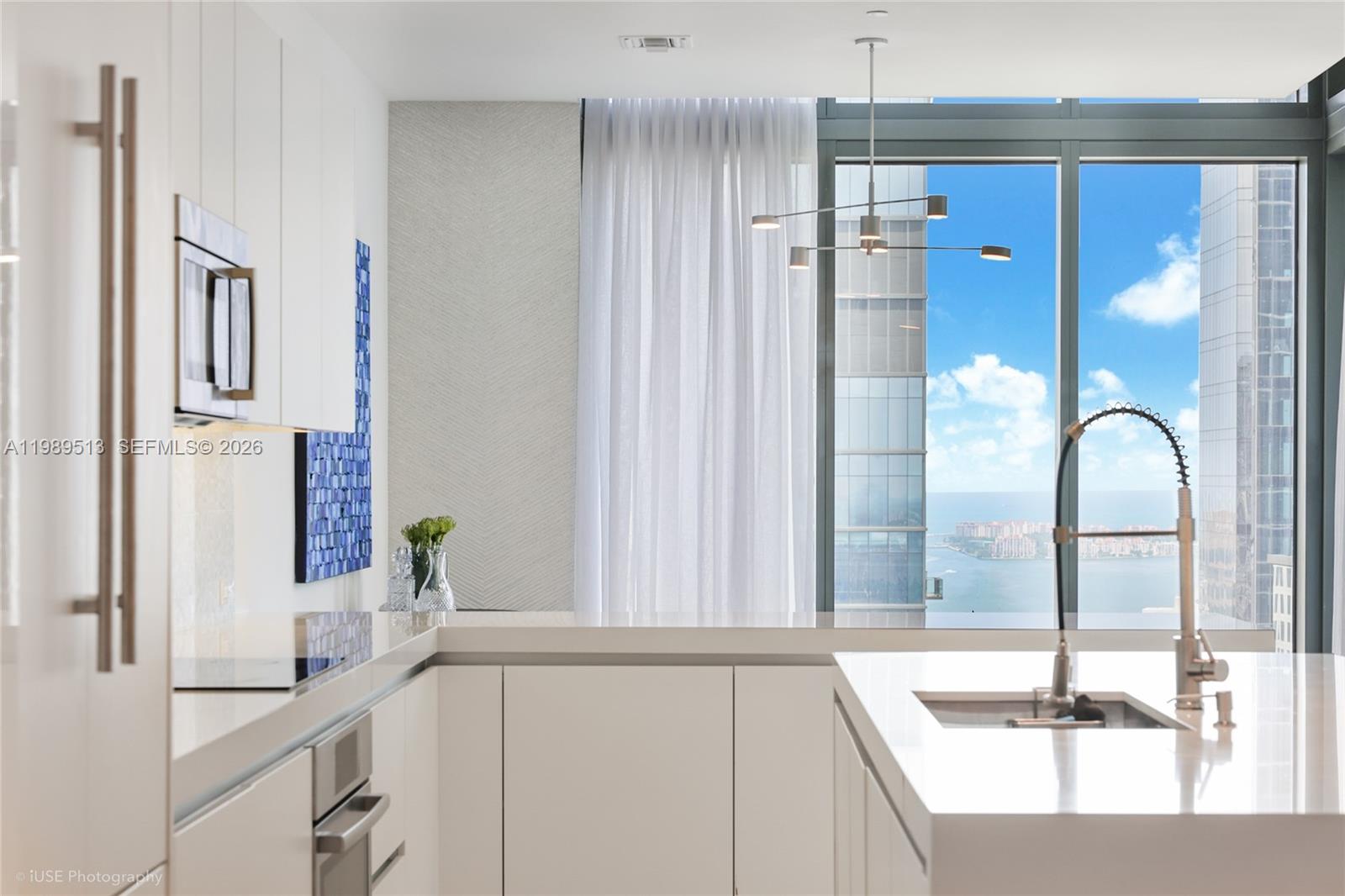 88 Southwest 7th Street, Unit 4101 Miami, FL 33130 - Photo 16 of 35 a kitchen with a sink and a large mirror
