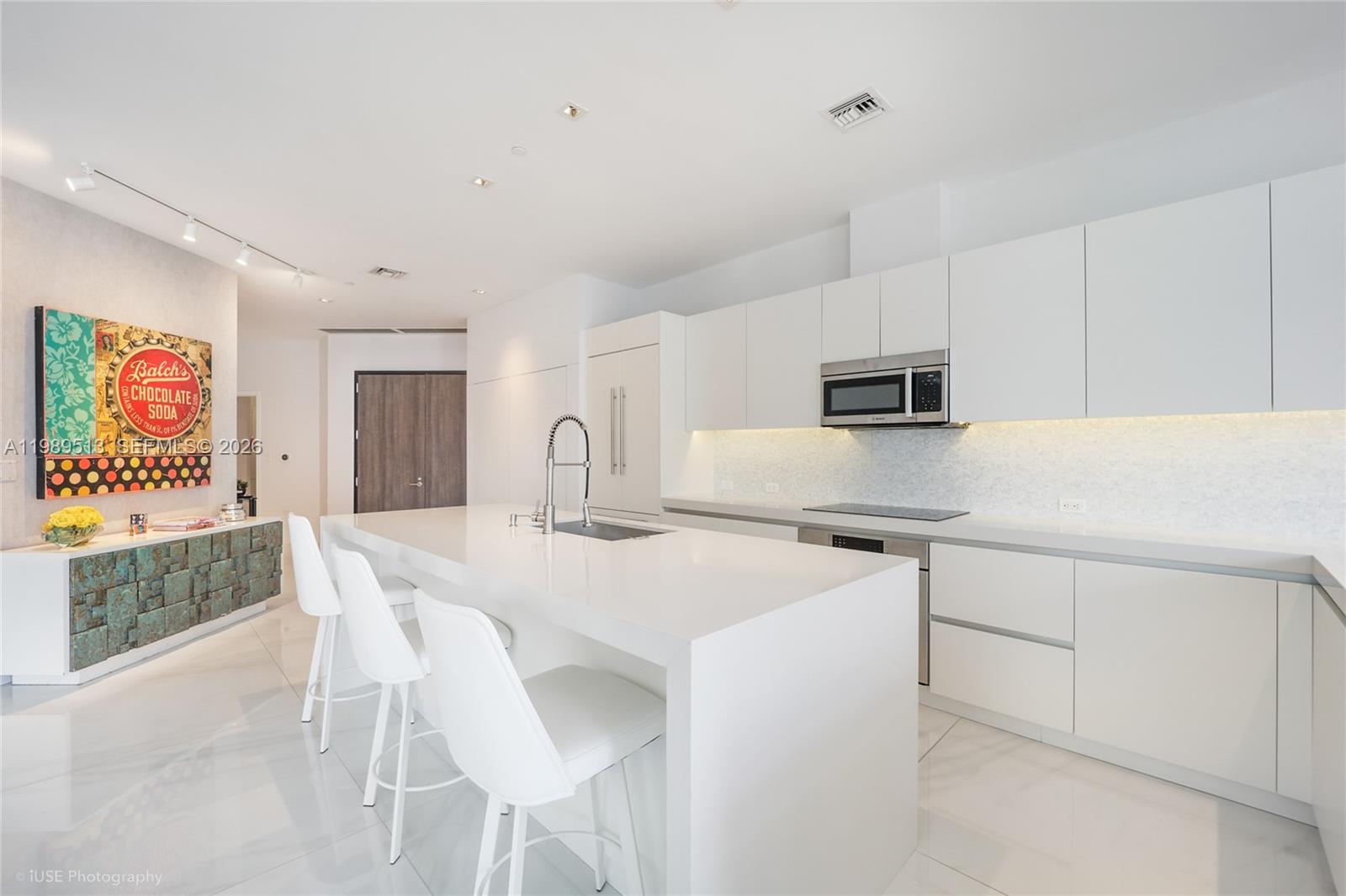 88 Southwest 7th Street, Unit 4101 Miami, FL 33130 - Photo 4 of 35 a kitchen with stainless steel appliances a white table chairs and a refrigerator