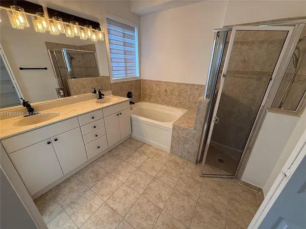 a bathroom with a tub sink and mirror