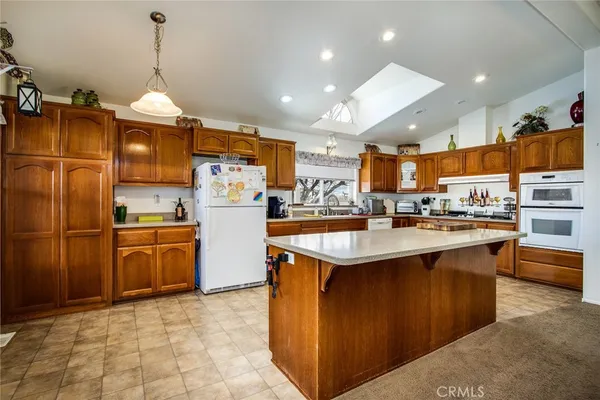 a kitchen with stainless steel appliances granite countertop a stove a sink dishwasher and a refrigerator