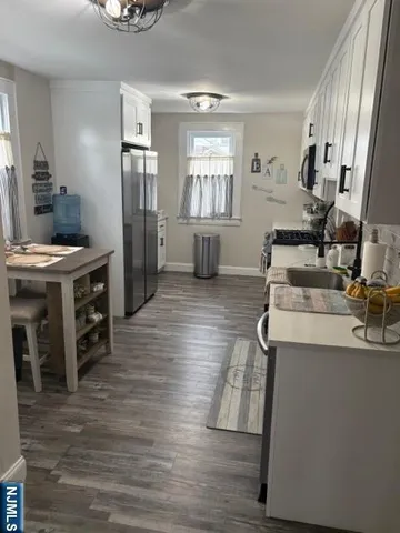 a view of a kitchen with furniture and wooden floor