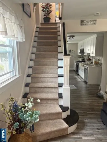 a view of entryway and hall with wooden floor