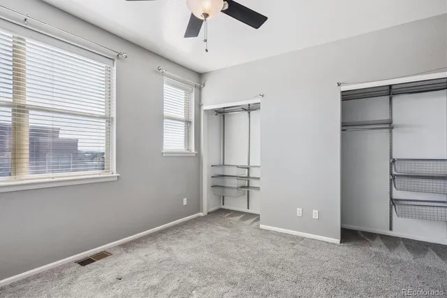 a view of empty room with window and ceiling fan