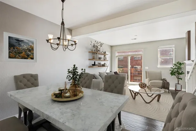 a view of a dining room with furniture a chandelier and wooden floor